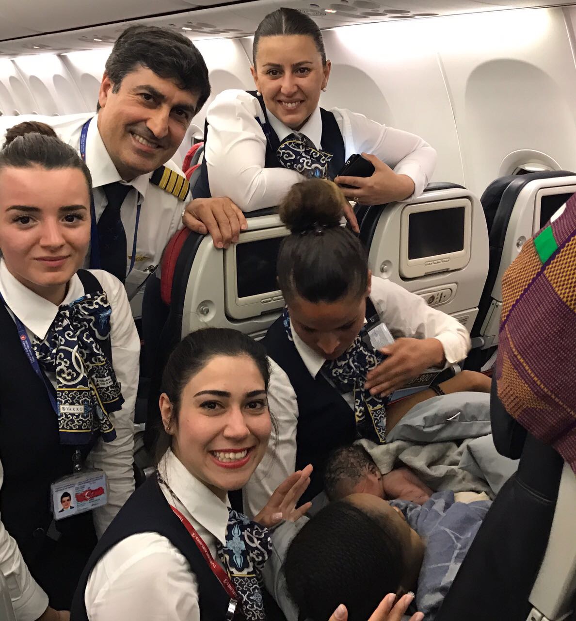 UNSPECIFIED - APRIL 7: (----EDITORIAL USE ONLY – MANDATORY CREDIT - "TURKISH AIRLINES / HANDOUT" - NO MARKETING NO ADVERTISING CAMPAIGNS - DISTRIBUTED AS A SERVICE TO CLIENTS----) A cabin crew of Turkish Airlines pose for a photo with a baby born in a plane during a flight from Conakry to Ouagadougou to Istanbul on April 7, 2017 in the air. Cabin crew helped the baby Kadiju's mother Diaby Nafi give birth and took photos with the baby. ( Turkish Airlines / Handout - Anadolu Agency )