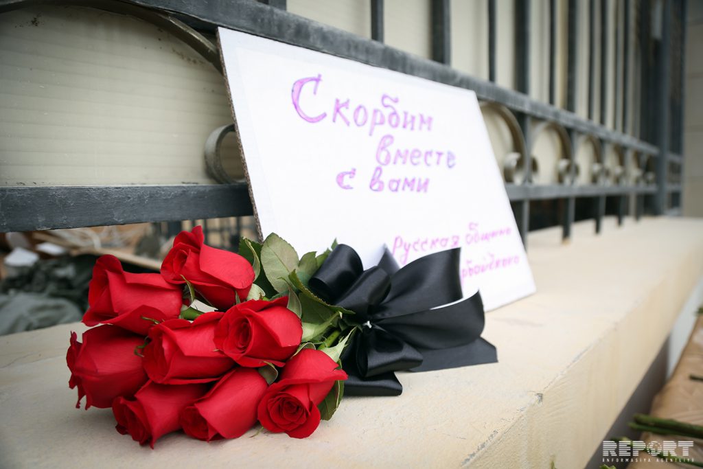 Жители Баку несут цветы к посольству России